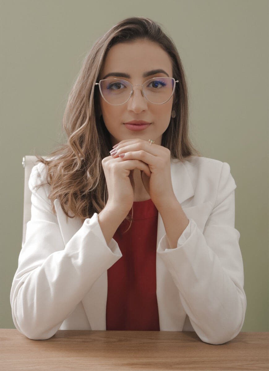 Isadora Franco sentada atrás de uma mesa